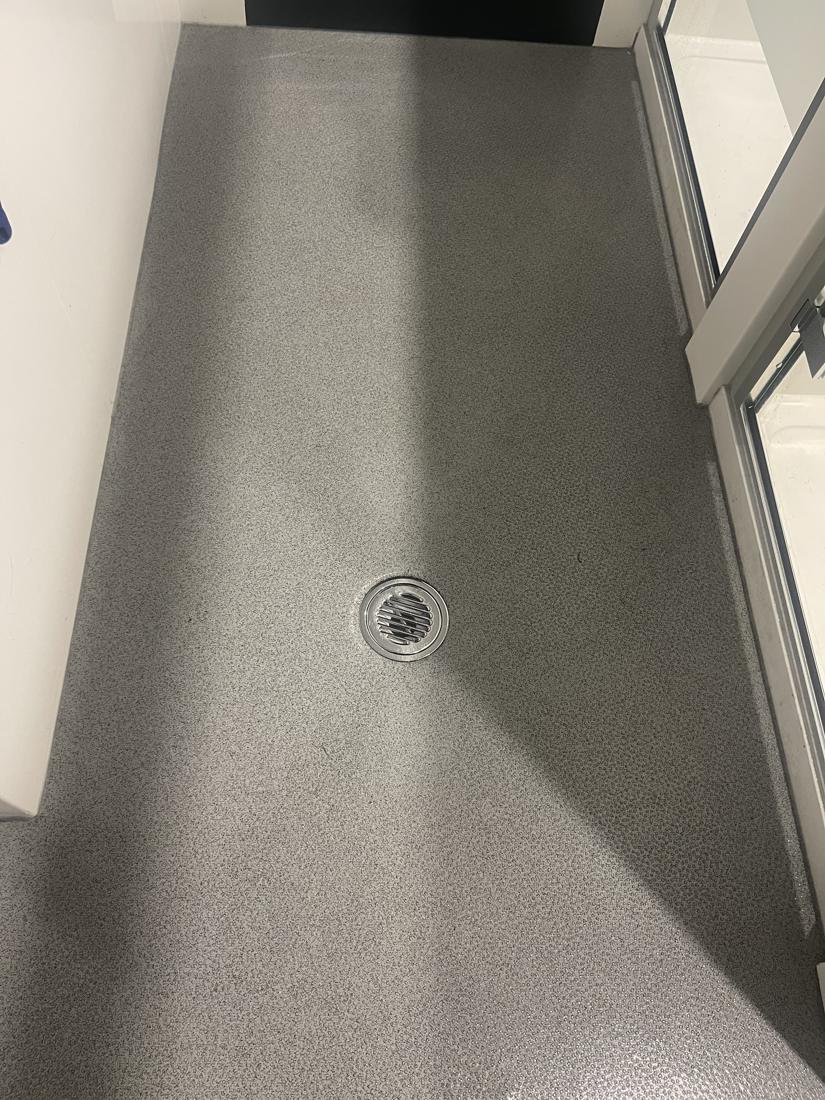 A clean entrance floor beside a glass door at a communal building cleaned by Cadence Clean
