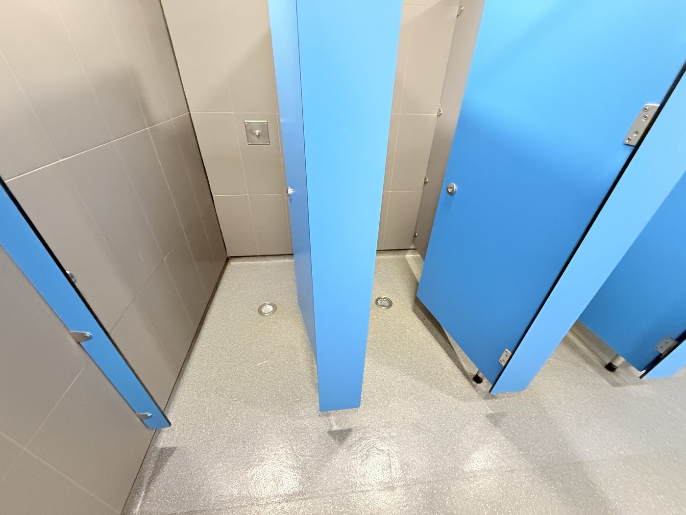 Spotless shower cubicles with floor drains at a gym cleaned by Cadence Clean